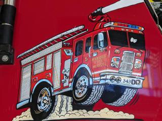 cartoon firetruck with riverdale iowa on the side